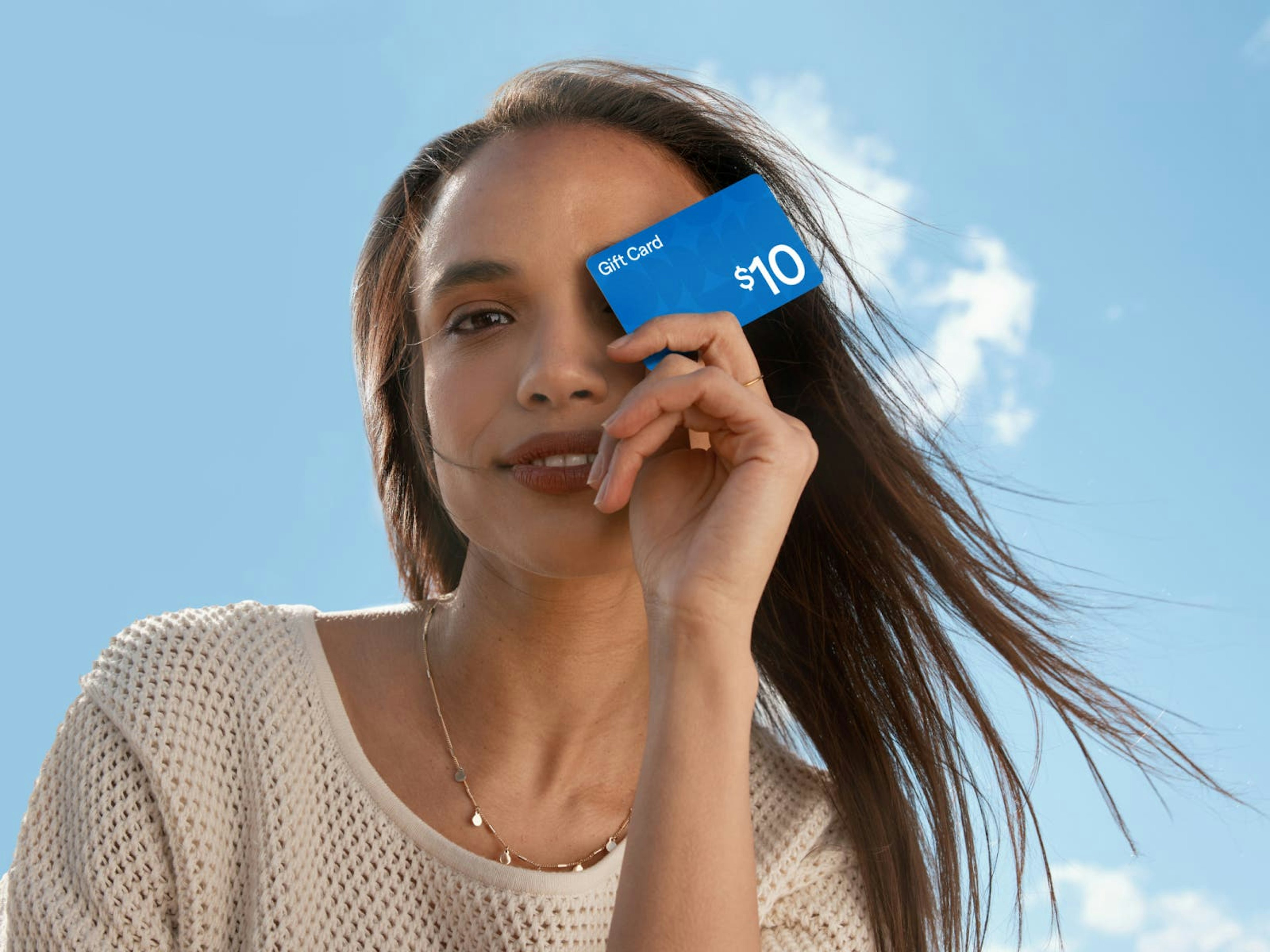 woman holding generic tanger gift card in front of face