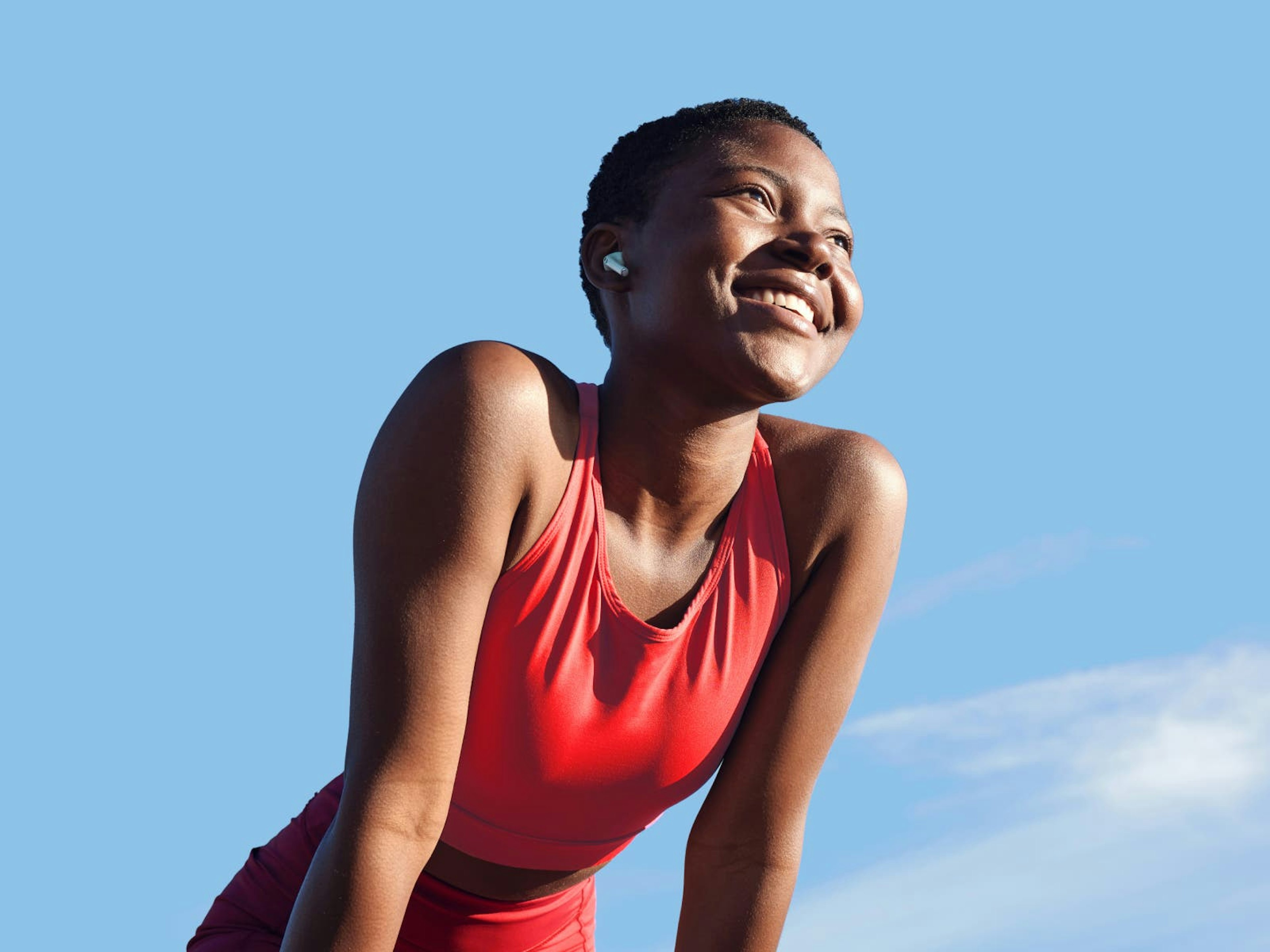 woman standing in red workout outfit smiling